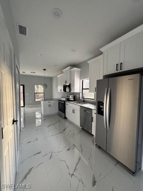 kitchen with stainless steel appliances, hanging light fixtures, plenty of natural light, white cabinets, and sink