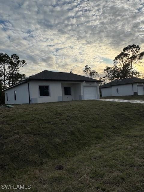 single story home with a garage and a lawn