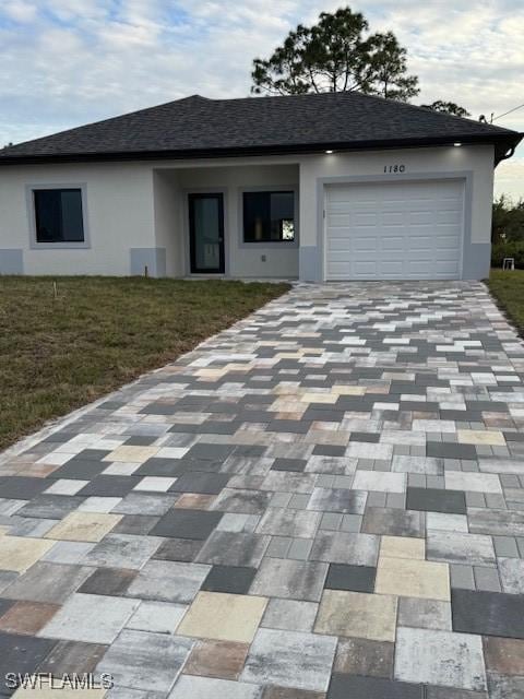 view of front of home featuring a front lawn and a garage