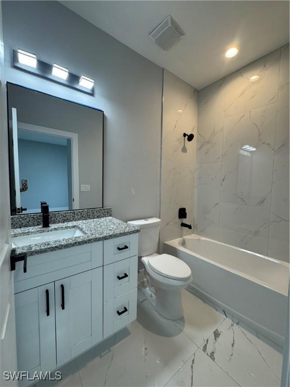 full bathroom with toilet, vanity, and tiled shower / bath