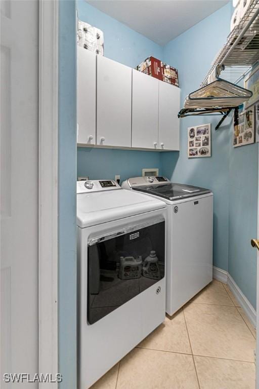 laundry area with cabinets, light tile patterned floors, and separate washer and dryer