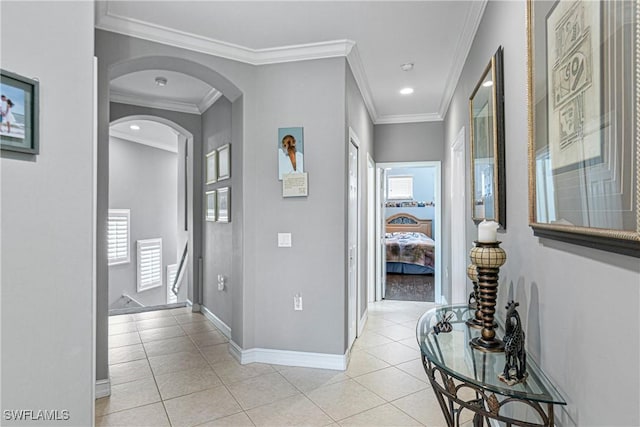 hall with light tile patterned floors and crown molding