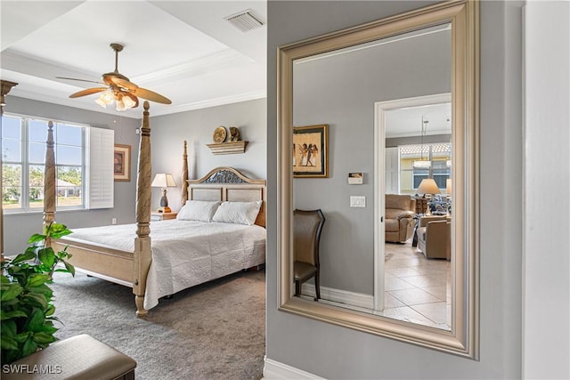 bedroom with carpet, a tray ceiling, ceiling fan, and ornamental molding