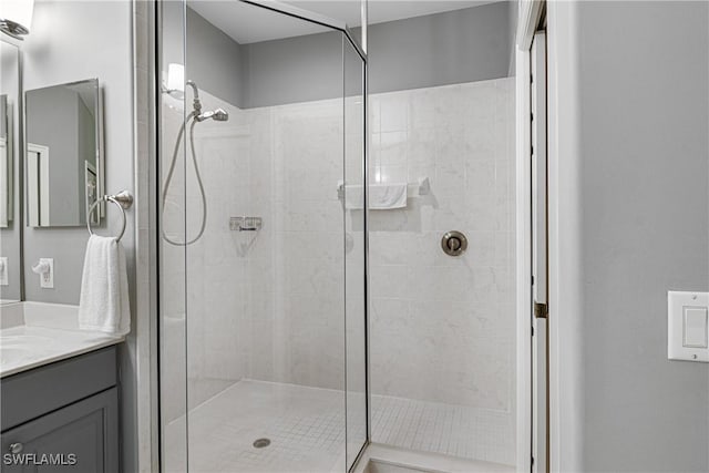 bathroom with vanity and a tile shower