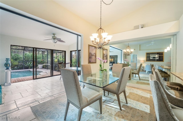 dining room with ceiling fan with notable chandelier, vaulted ceiling, and plenty of natural light