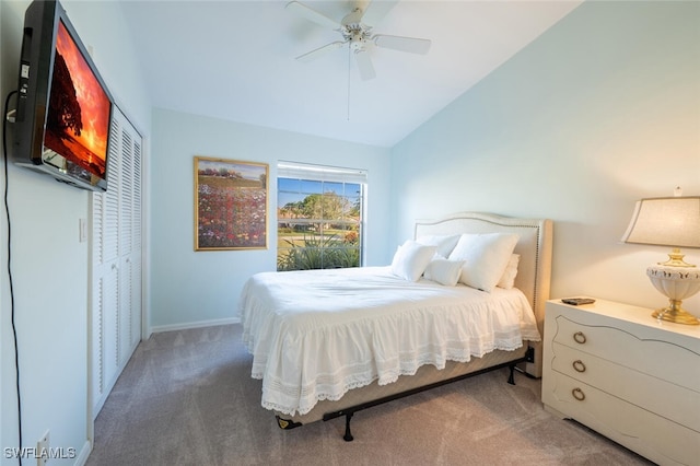 carpeted bedroom with ceiling fan, lofted ceiling, and a closet