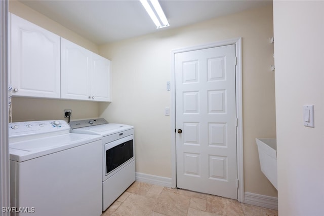 washroom featuring cabinets and washing machine and clothes dryer