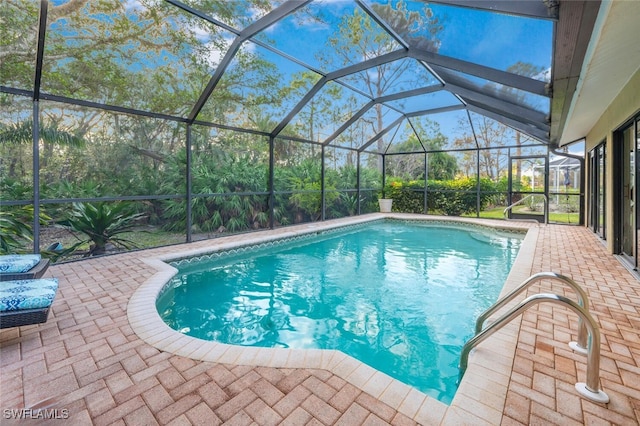 view of pool featuring glass enclosure and a patio area