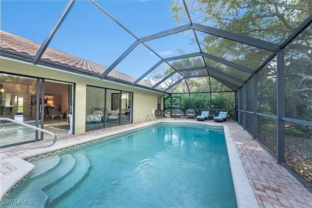 view of swimming pool featuring a lanai and a patio