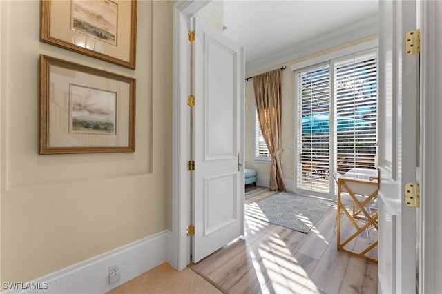 doorway to outside with light hardwood / wood-style flooring and ornamental molding