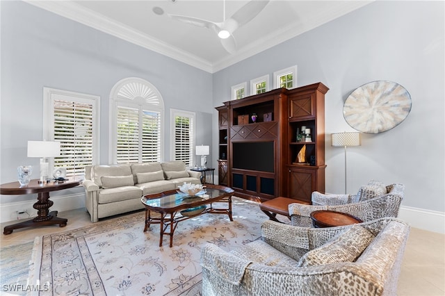 living room featuring ceiling fan, light tile patterned flooring, ornamental molding, and a high ceiling