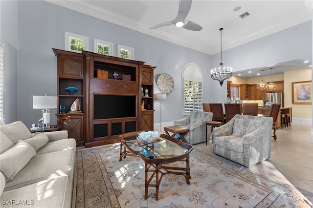 living room featuring a towering ceiling, ceiling fan with notable chandelier, and ornamental molding