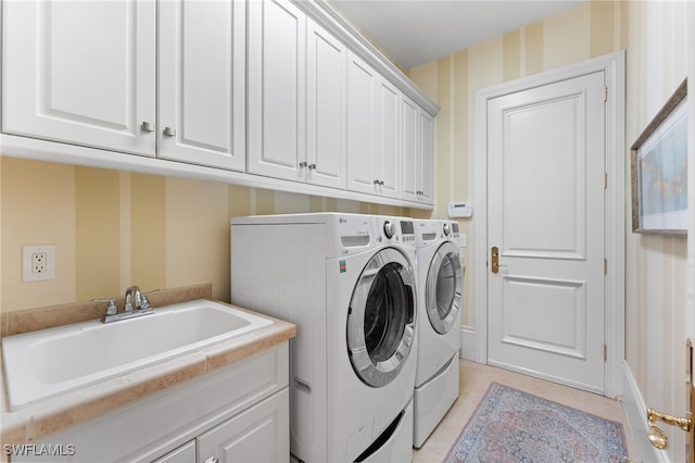 clothes washing area with washer and clothes dryer, light tile patterned flooring, cabinets, and sink