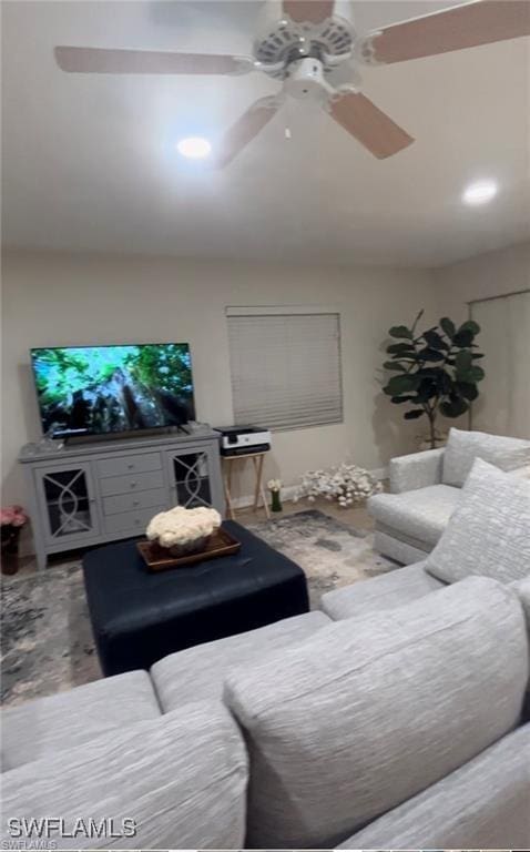 living room with wood-type flooring and ceiling fan