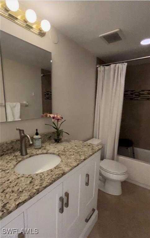 full bathroom with vanity, shower / tub combo with curtain, and toilet