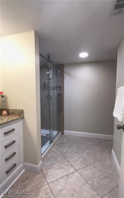 bathroom featuring vanity and a shower with shower door