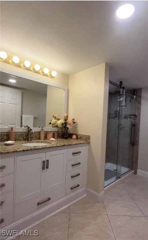 bathroom featuring vanity, an enclosed shower, and tile patterned flooring