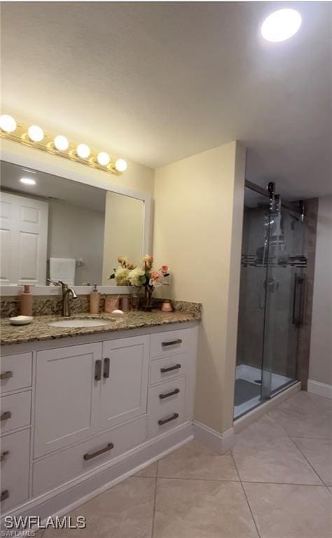 bathroom with vanity, a shower with shower door, and tile patterned flooring