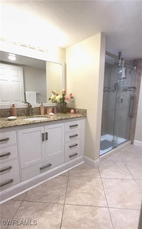 bathroom with vanity, tile patterned flooring, and walk in shower