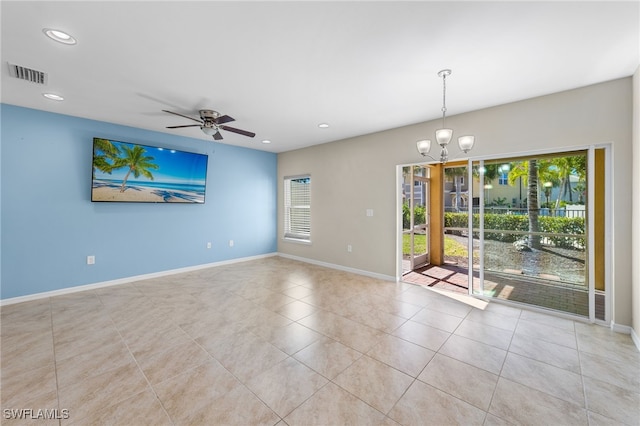 tiled spare room featuring ceiling fan with notable chandelier