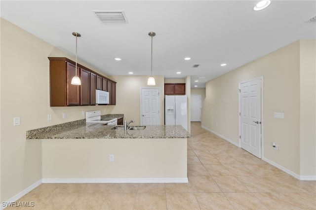 kitchen with light stone countertops, kitchen peninsula, white appliances, sink, and hanging light fixtures