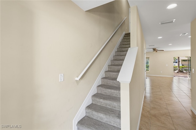 stairs with tile patterned flooring and ceiling fan