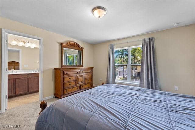 carpeted bedroom with ensuite bathroom and sink