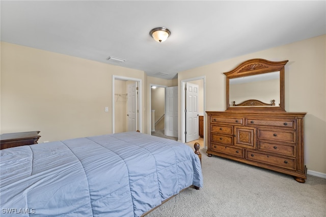 carpeted bedroom with a spacious closet and a closet