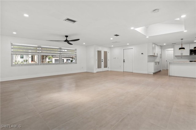 unfurnished living room featuring ceiling fan and light tile patterned flooring