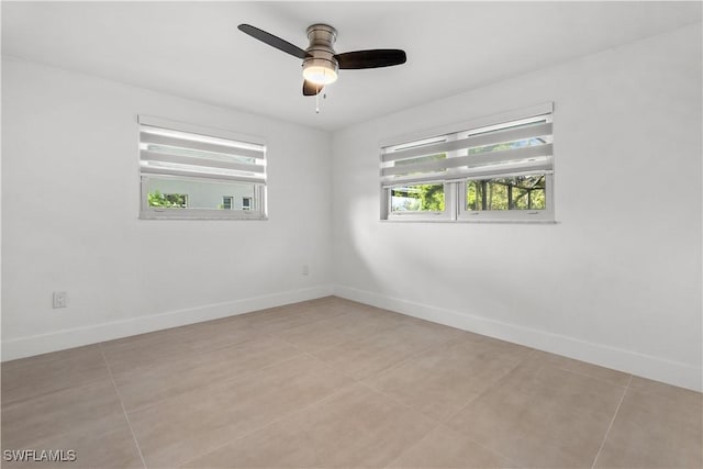 unfurnished room featuring a healthy amount of sunlight, light tile patterned floors, and ceiling fan