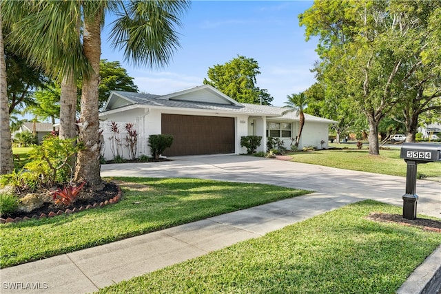 ranch-style home featuring a garage and a front lawn