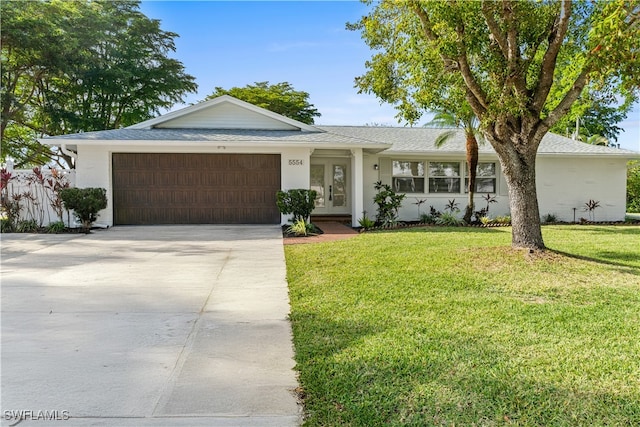 ranch-style house with french doors, a garage, and a front lawn