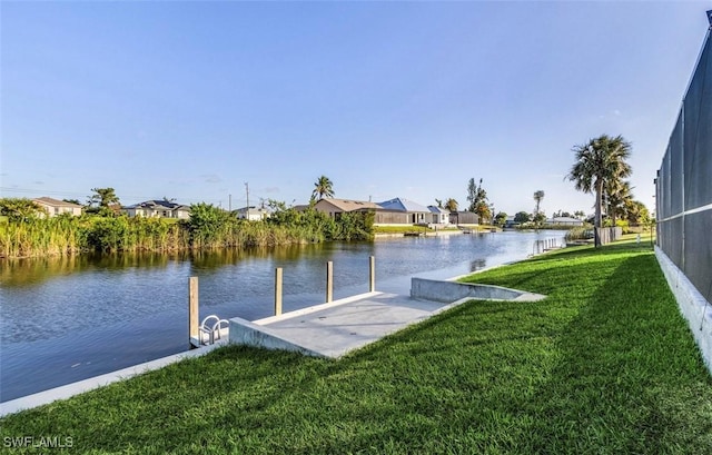 dock area featuring a lawn and a water view