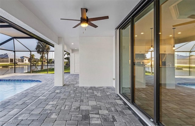 view of swimming pool featuring a patio, ceiling fan, and a lanai