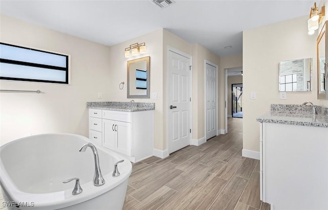 bathroom featuring a tub to relax in and vanity