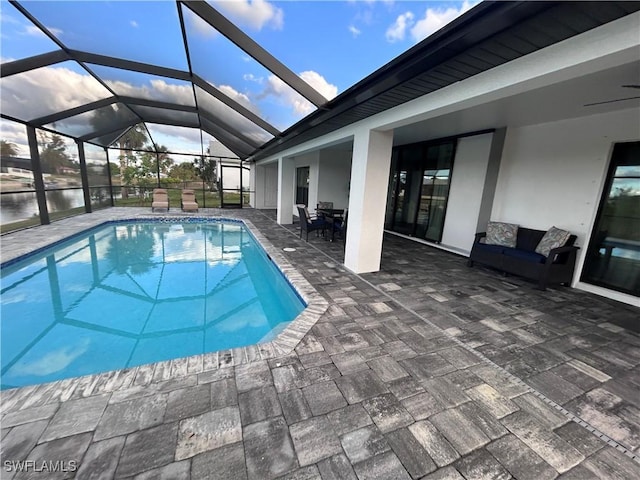 view of pool featuring glass enclosure and a patio