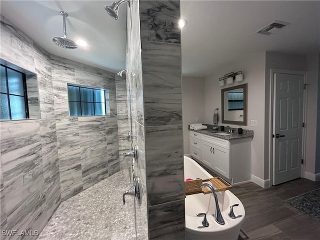 bathroom featuring a tile shower and vanity