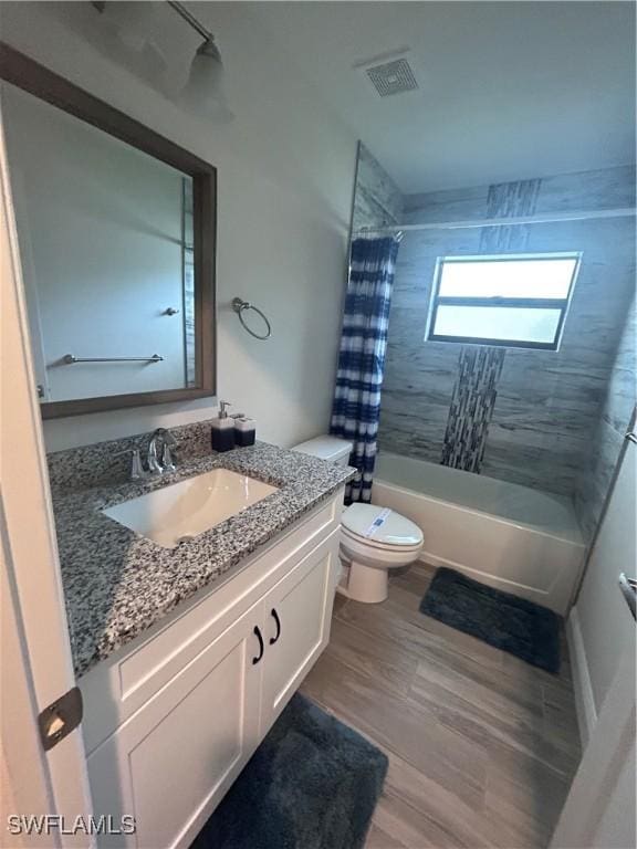 full bathroom featuring hardwood / wood-style flooring, vanity, toilet, and shower / tub combo with curtain