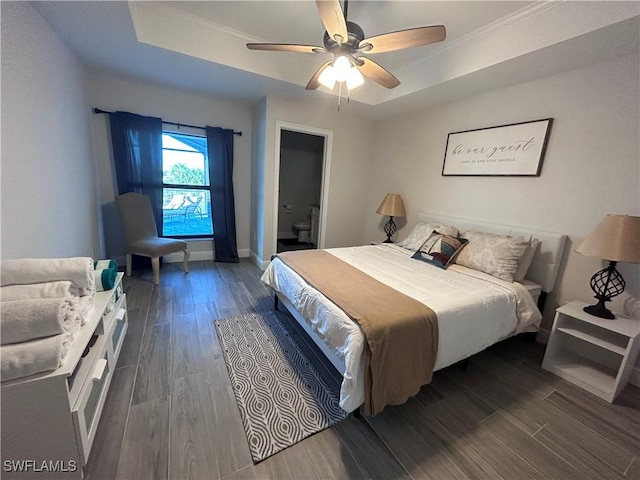 bedroom with a raised ceiling, ceiling fan, and dark wood-type flooring