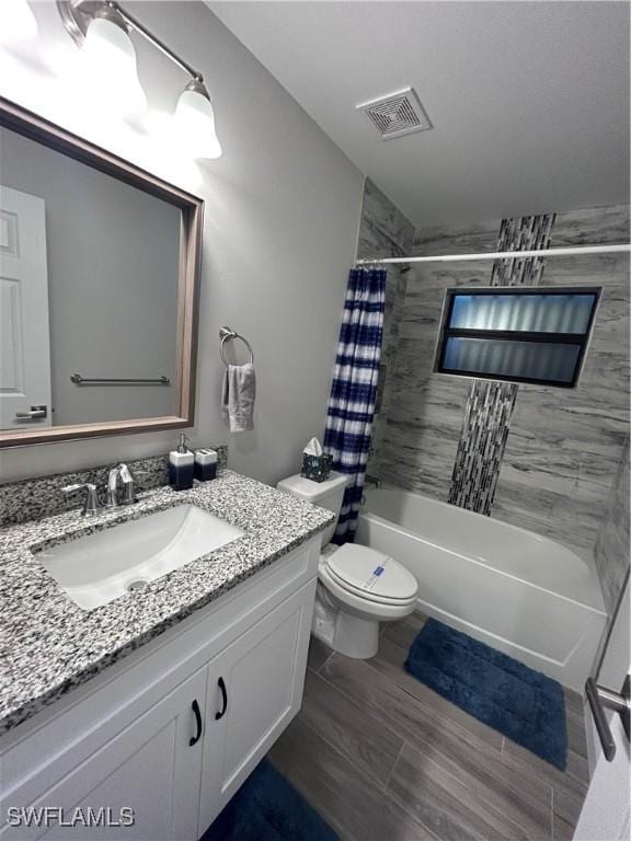 full bathroom with shower / tub combo with curtain, vanity, and toilet