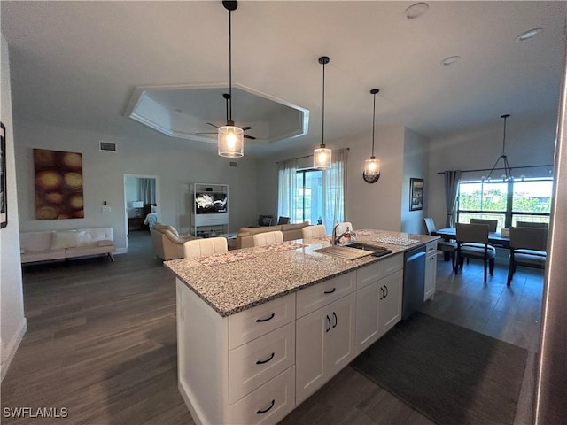 kitchen with dishwasher, sink, light stone countertops, a tray ceiling, and white cabinetry