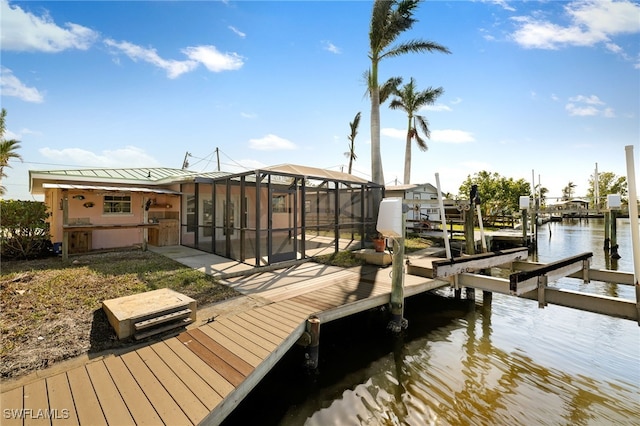 view of dock with a lanai and a water view