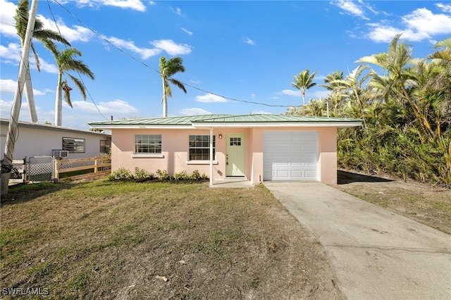 single story home with a garage and a front lawn