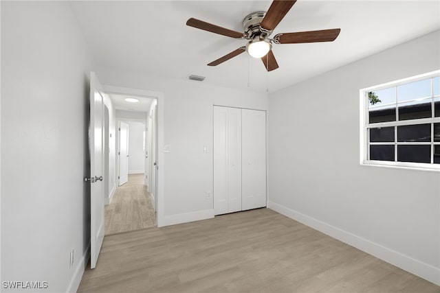 unfurnished bedroom featuring ceiling fan, light hardwood / wood-style flooring, and a closet