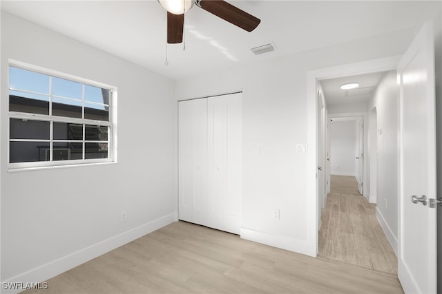 unfurnished bedroom with ceiling fan, a closet, and light hardwood / wood-style floors