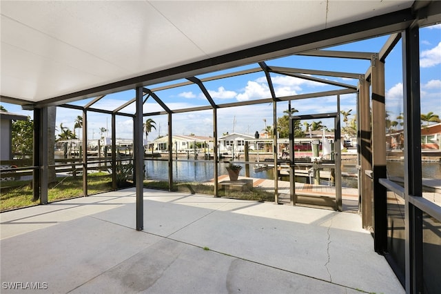 view of patio / terrace featuring glass enclosure, a dock, and a water view