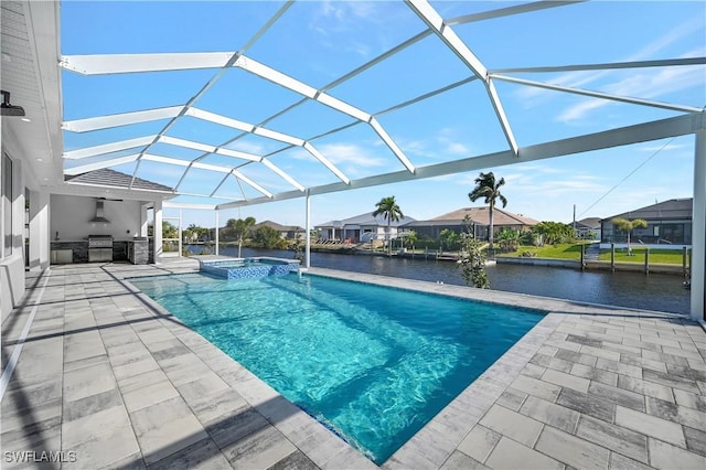 view of pool featuring an outdoor kitchen, a grill, a water view, and glass enclosure