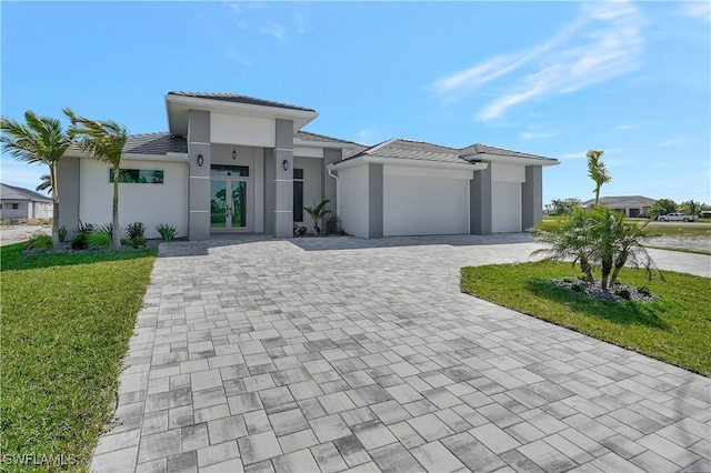 view of front of house with a front yard, french doors, and a garage