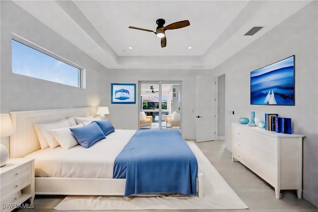 bedroom with a tray ceiling, ceiling fan, and light hardwood / wood-style floors