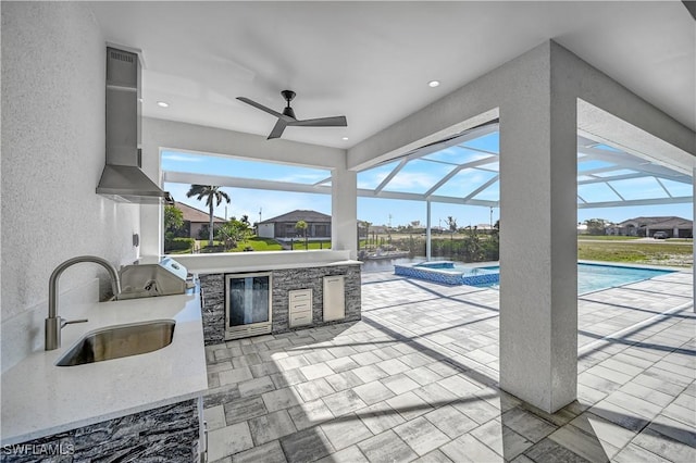 view of patio with area for grilling, a swimming pool with hot tub, glass enclosure, and a wet bar